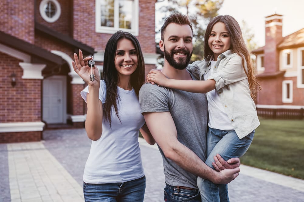 Happy,Family,Is,Standing,With,Keys,From,Their,New,House