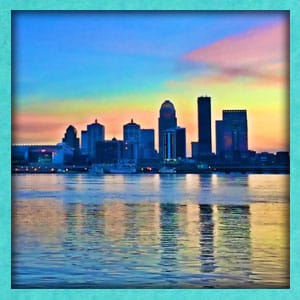 Image of the skyline of Louisville in morning. The skyline is reflected in the Ohio river.