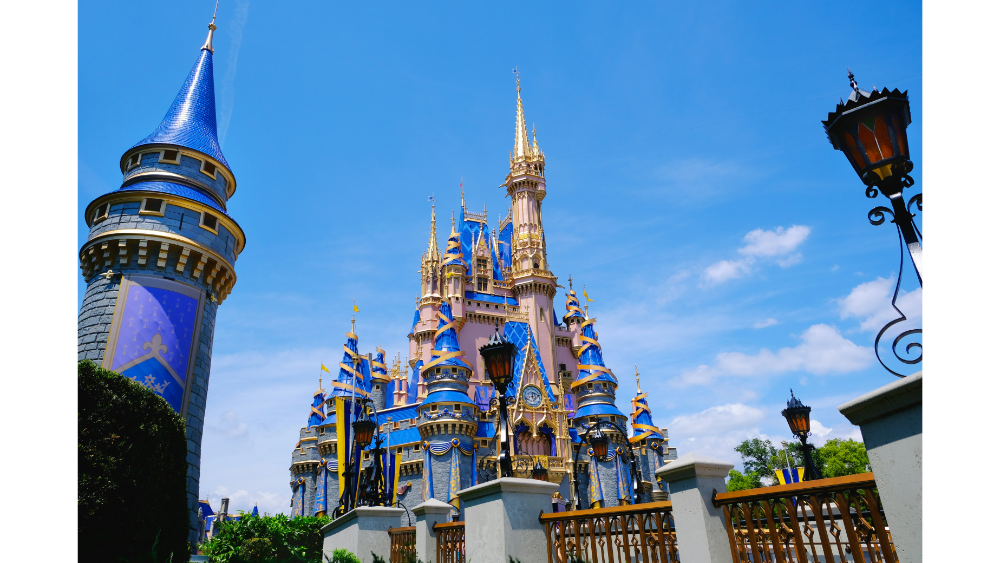 Colorful, whimsical view of Cinderella’s Castle at Walt Disney World with bright blue skies and decorative towers.