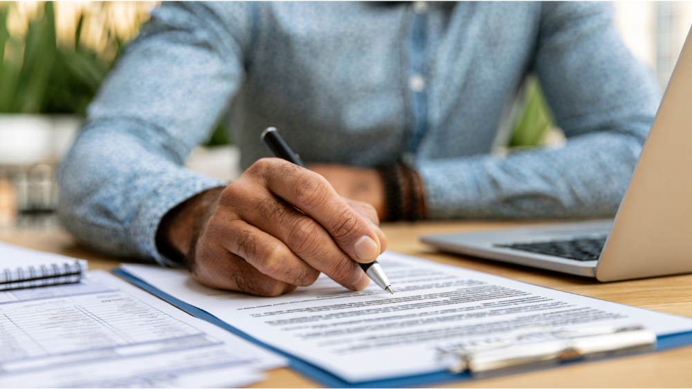 Professional property manager reviewing tenant applications, credit reports, and lease documents before approving a rental applicant.