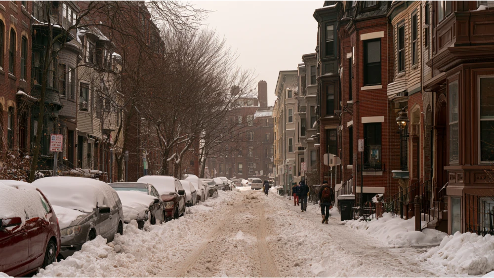 Snow-covered Cambridge Massachusetts residential street with cleared sidewalks and parked cars