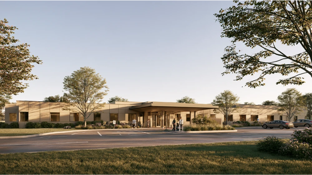 A modern community medical center in East Greenwich, Rhode Island, with an accessible entrance and patients arriving for appointments.