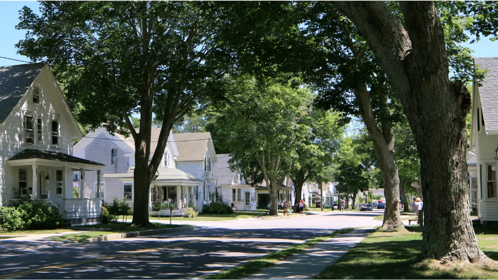 Residents walking through a South Kingstown village near local shops and traditional New England homes.