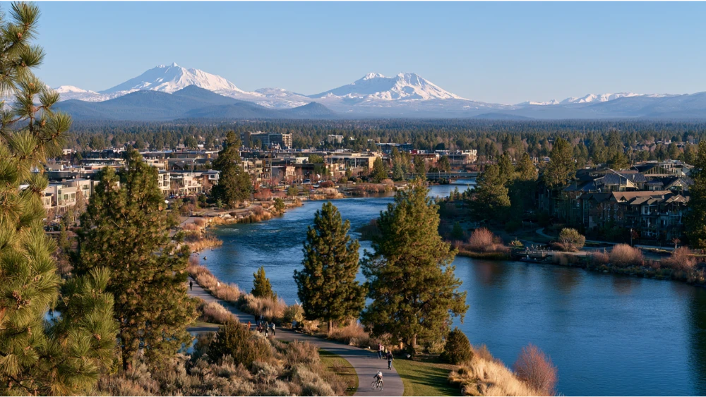 People enjoying an outdoor dining area in Bend, Oregon, with local food vendors, neighborhood restaurants, pine trees, and a relaxed Central Oregon atmosphere.