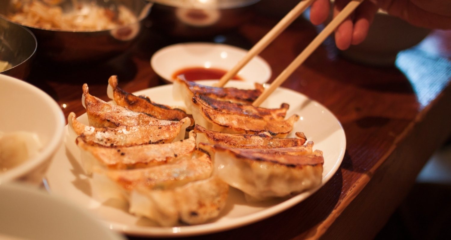 Crispy,Pan-fried,Japanese,Gyoza,Dumplings,On,A,Brown,Table,,With