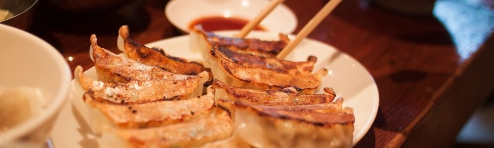 Crispy,Pan-fried,Japanese,Gyoza,Dumplings,On,A,Brown,Table,,With